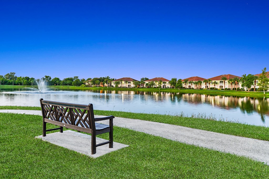 A park bench overlooking the water on a walking path at Bay Breeze apartments in Fort Myers, Florida