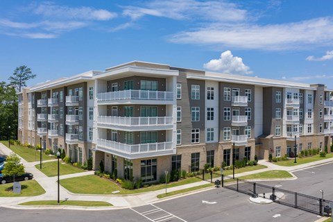 A large apartment complex with a parking lot in front.