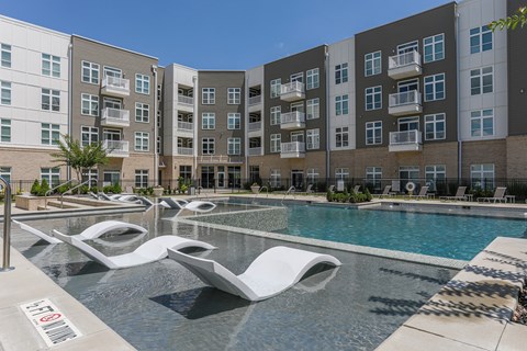 A pool area with a white sculpture in the middle of the pool.