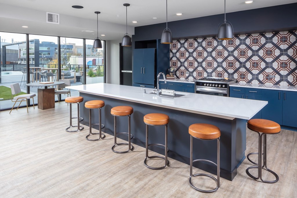 a communal kitchen with bar stools and a large window with a city view at Maven on Broadway, Minnesota, 55904
