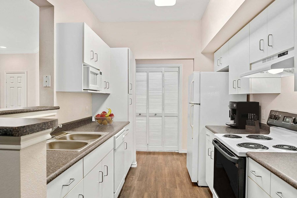 a kitchen with white cabinets and electric stove at The Lodge at Lakeline Village, Texas, 78613