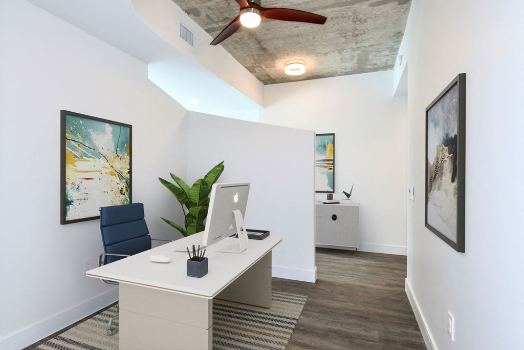 a white desk with a computer in a room with white walls and a ceiling with a fan at Element, Tampa, 33602