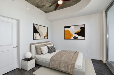 a bedroom with a bed and two paintings on the wall - Photo Gallery 4