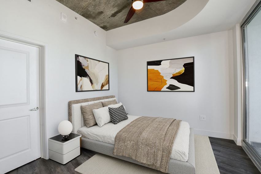 Bedroom with Wood-Style Plank Flooring a bedroom with a bed and two paintings on the wall
