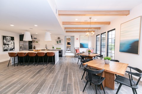 Clubroom with wooden tables and chairs at Emblem Alpharetta Apartments, Alpharetta