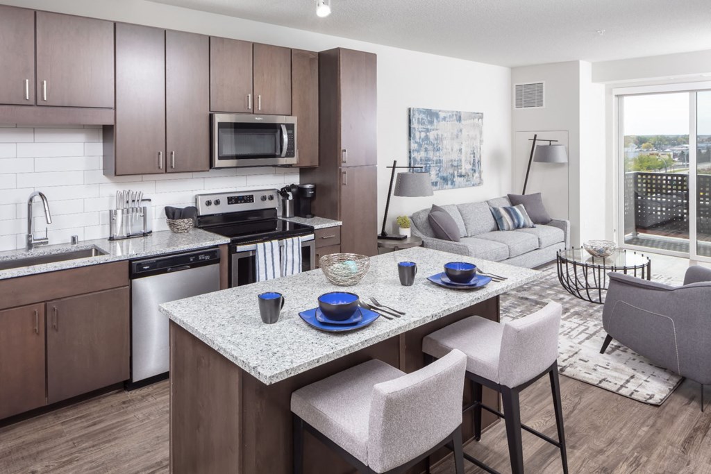 an open kitchen and living room with a marble counter top at Maven on Broadway, Minnesota