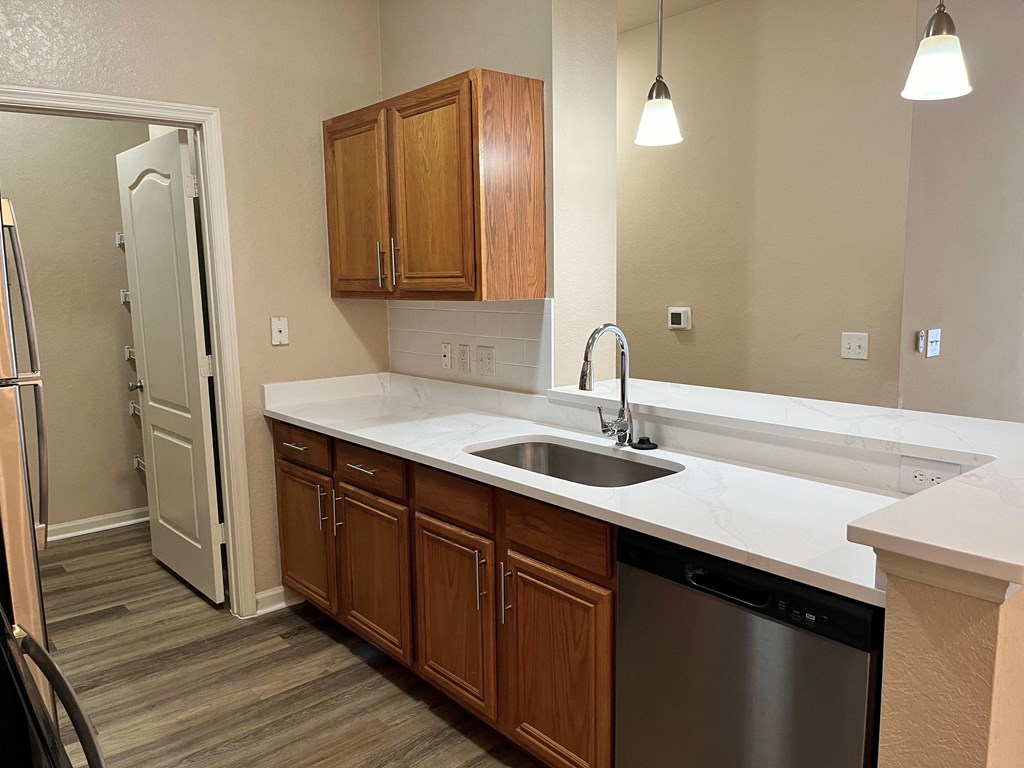 an empty kitchen with a sink and a refrigerator