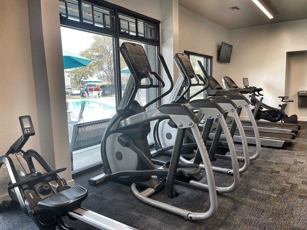a row of treadmills and elliptical trainers in a gym at 2300 West Apartments, Reno, NV, 89502