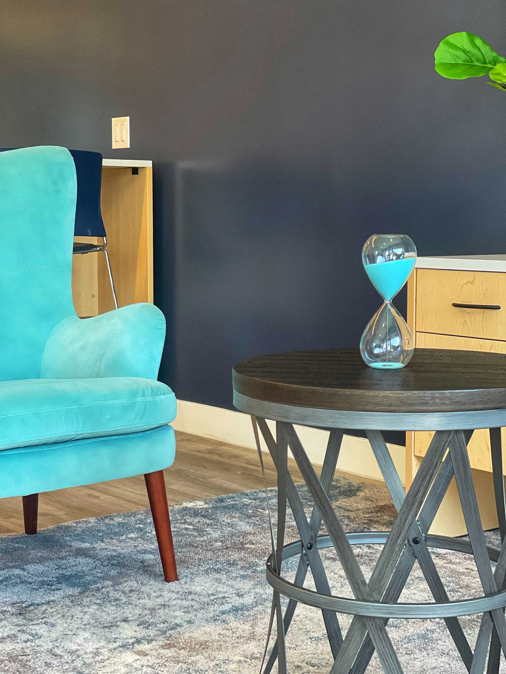 a blue chair and a round table with an hourglass on it at 2300 West Apartments, Nevada, 89502