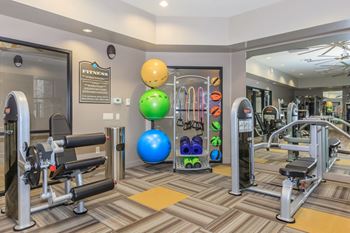 a gym with weights and other exercise equipment at the monarch luxury apartments in des plaines