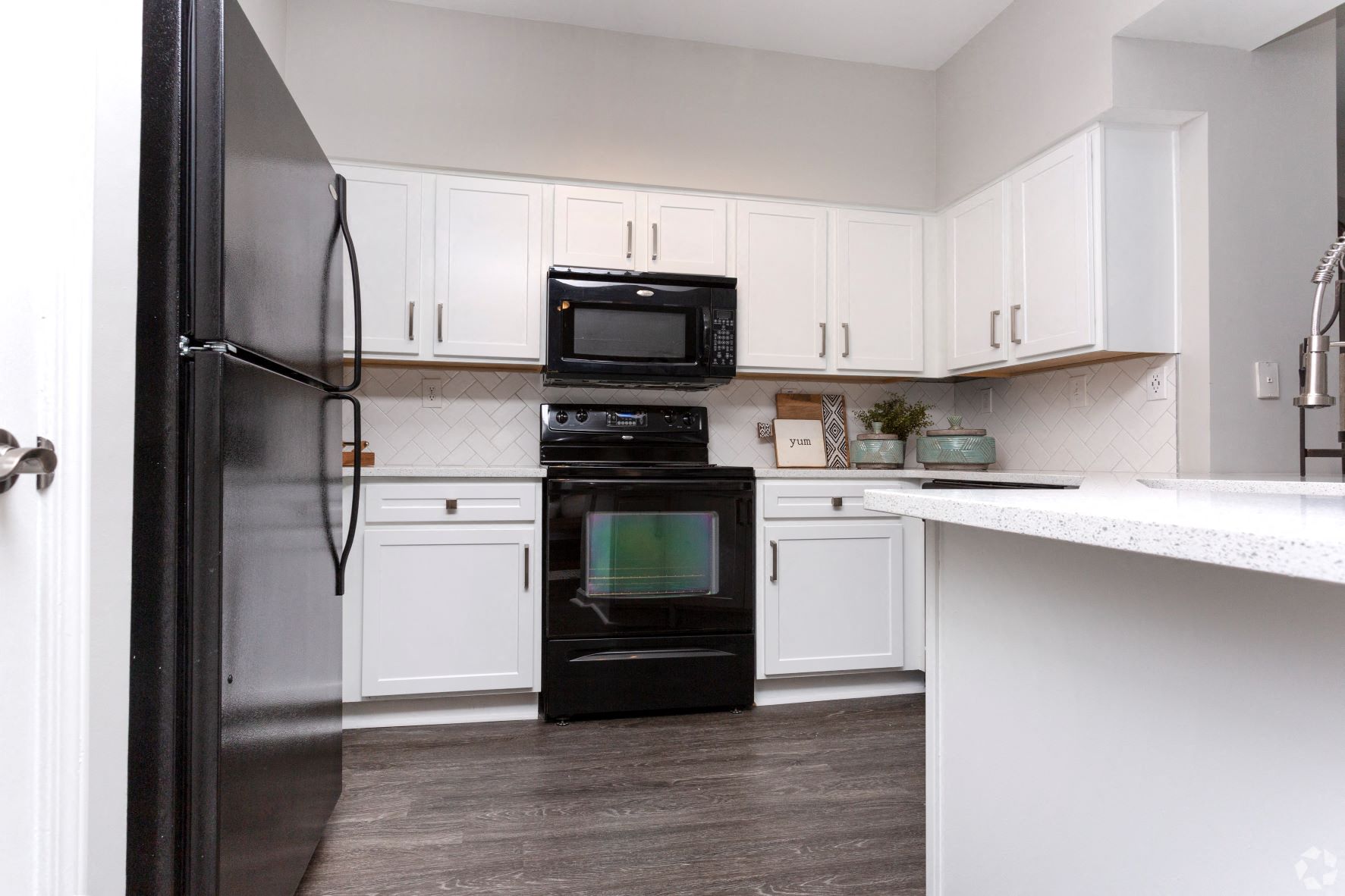 Modern kitchen with black appliances at Emblem Alpharetta, Alpharetta, Georgia