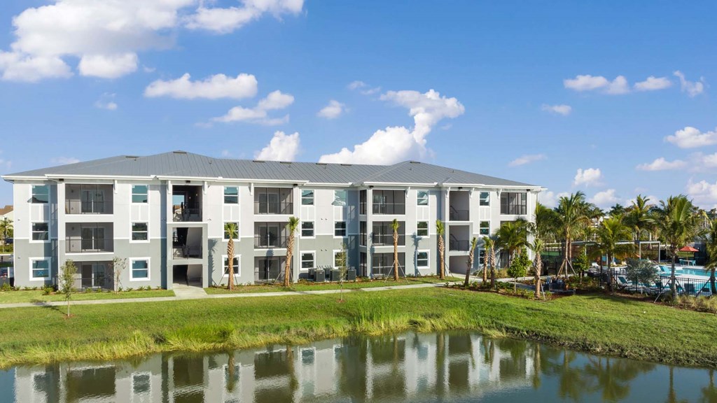 A modern building with a pool in front. at Lucie at Tradition Apartments, Port St. Lucie