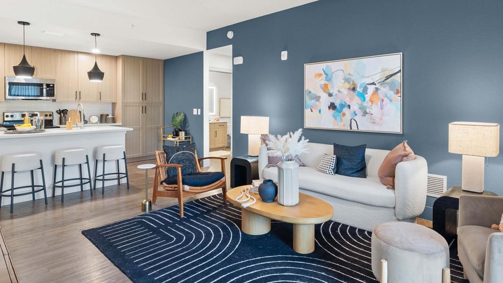 A modern living room with a kitchen area in the background. at Lucie at Tradition Apartments, Florida