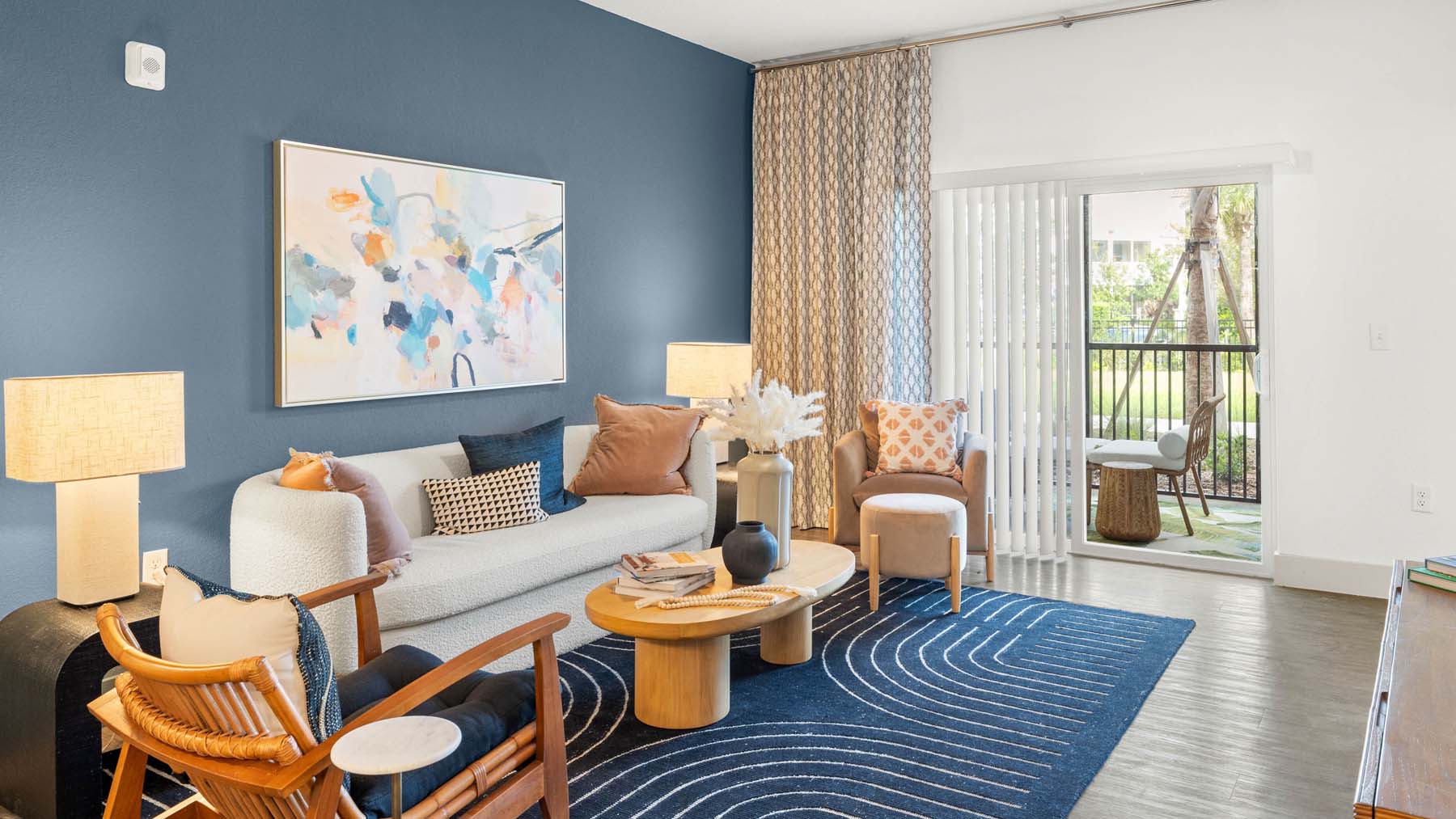 A living room with a blue wall and a painting on it.