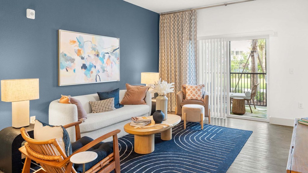 A living room with a blue wall and a painting on it. at Lucie at Tradition Apartments, Port St. Lucie, FL, 34987