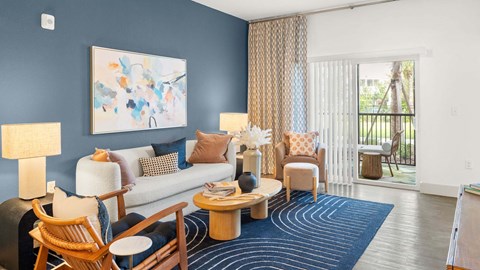 A living room with a blue wall and a painting on it. at Lucie at Tradition Apartments, Port St. Lucie, FL, 34987