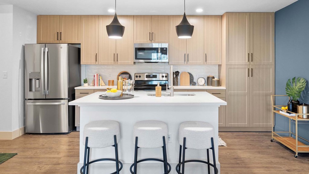 A modern kitchen with a white island and stainless steel appliances. at Lucie at Tradition Apartments, Port St. Lucie, Florida