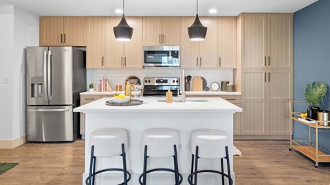 A modern kitchen with a white island and stainless steel appliances. at Lucie at Tradition Apartments, Port St. Lucie, Florida