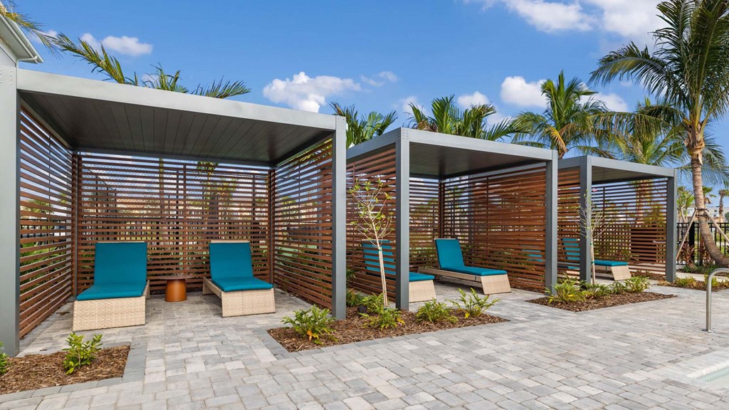 A modern outdoor seating area with blue chairs and wooden slats. at Lucie at Tradition Apartments, Port St. Lucie 34987