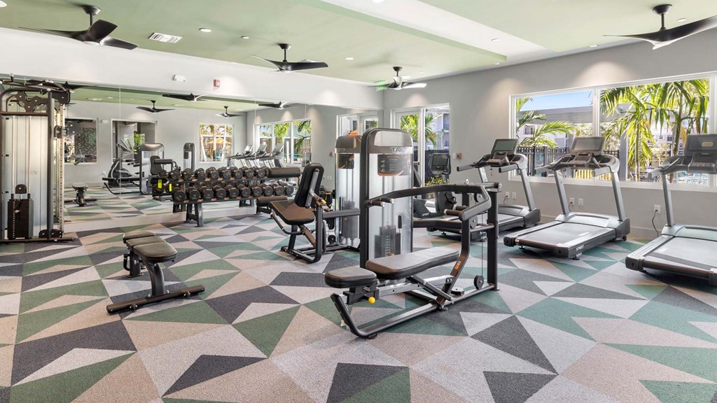 A gym with a variety of equipment including treadmills, weights, and exercise machines. at Lucie at Tradition Apartments, Port St. Lucie, Florida