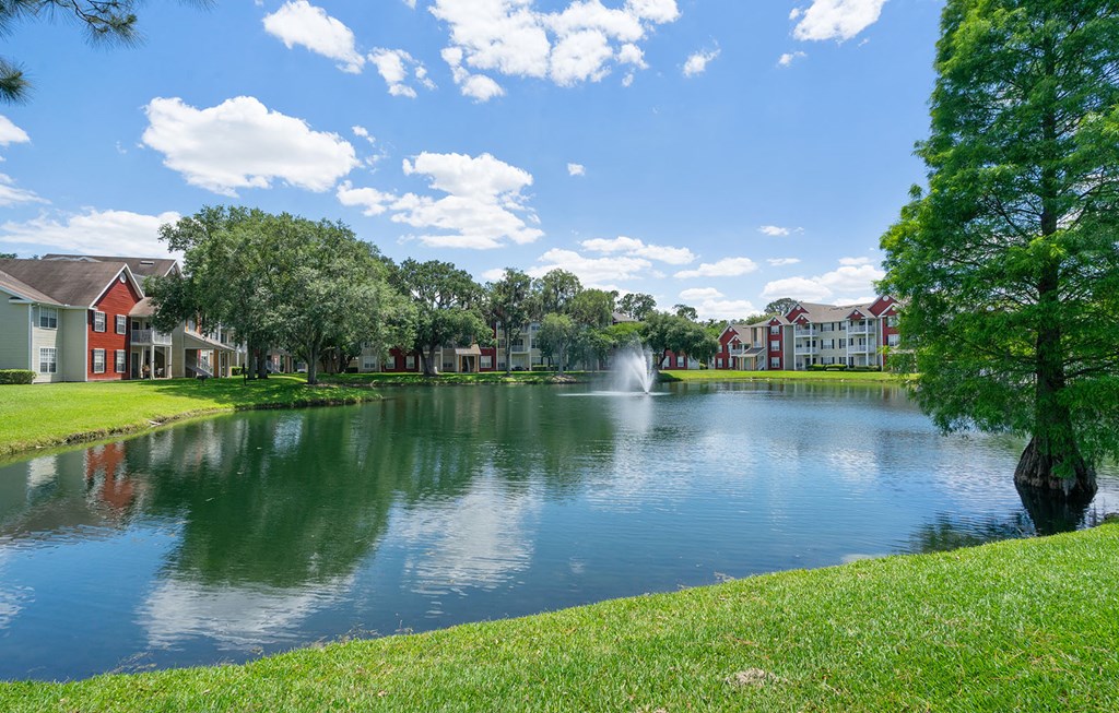 a pond with a fountain in front of some apartments at Bella Vista on Park, Plant City, 33563