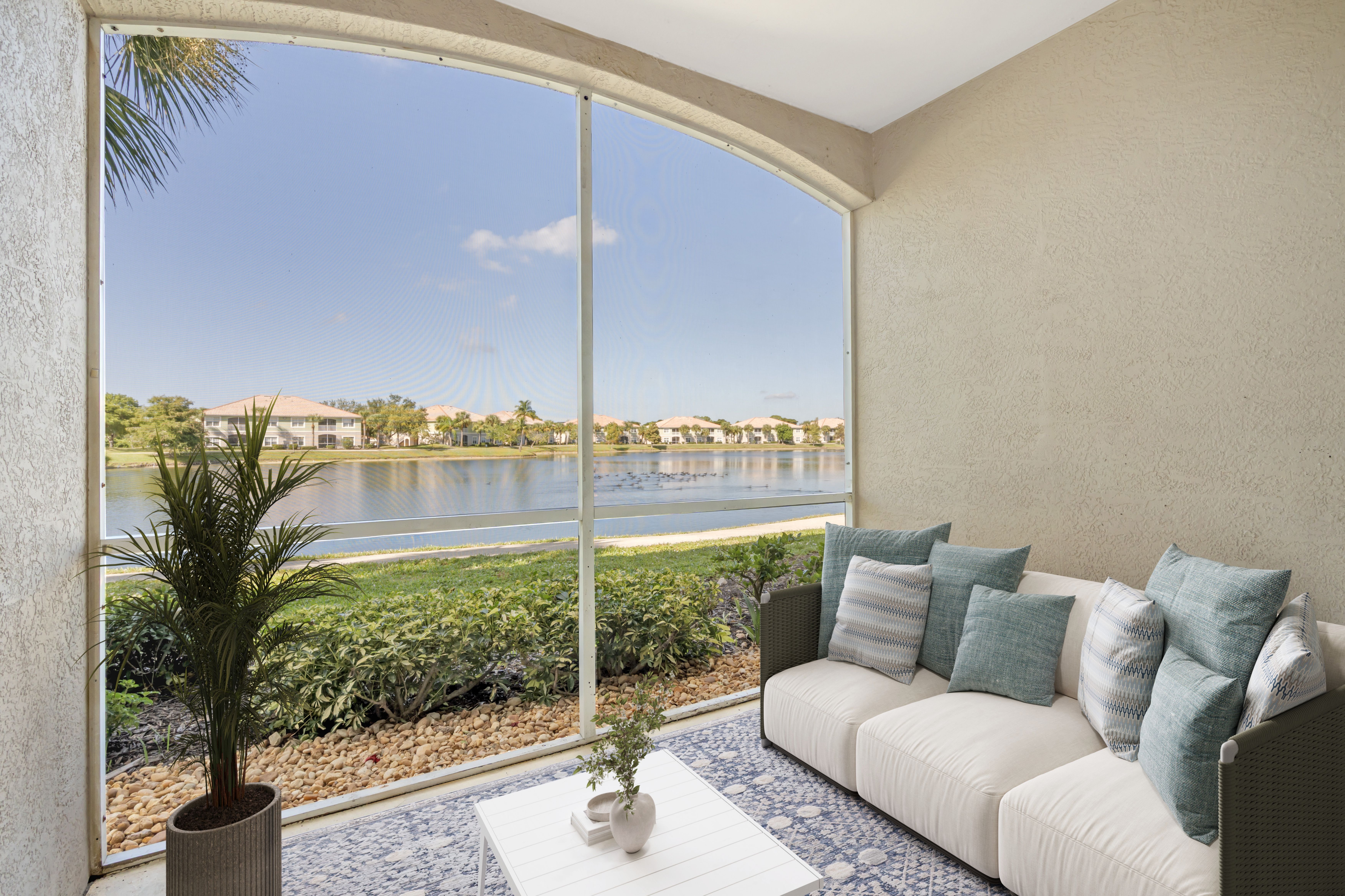 A living room with a couch and a view of a lake through the window.