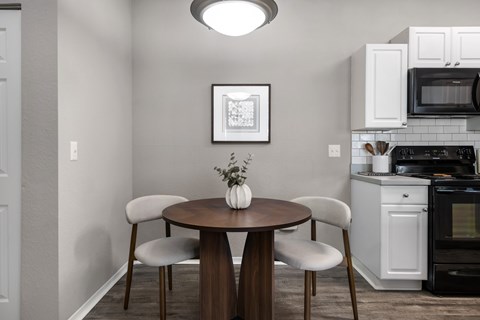 A kitchen with a table and chairs.