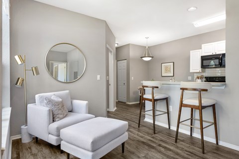 A modern living room with a white chair and ottoman.