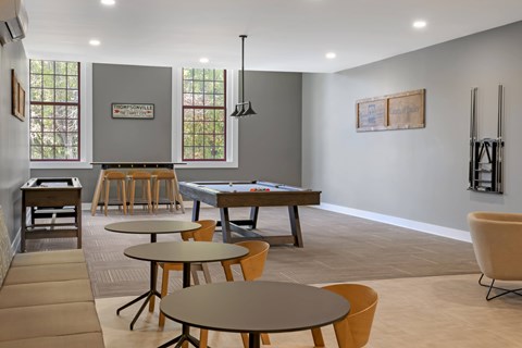 A community game room with a pool table and chairs.