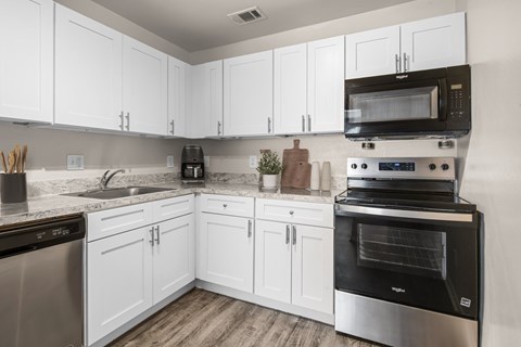 A kitchen with white cabinets and stainless steel appliances.