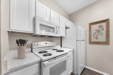 A kitchen with white appliances and cabinets.