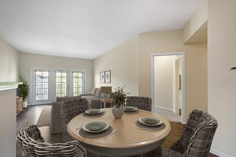 A dining room with a round table surrounded by chairs.