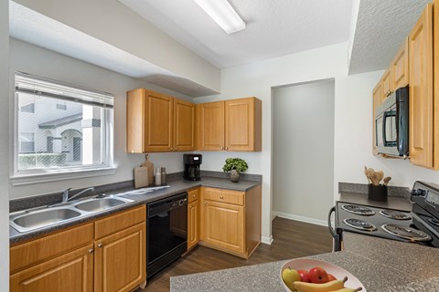 A kitchen with wooden cabinets and a black oven.