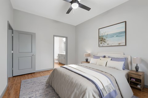 A bedroom with a large bed and a ceiling fan.