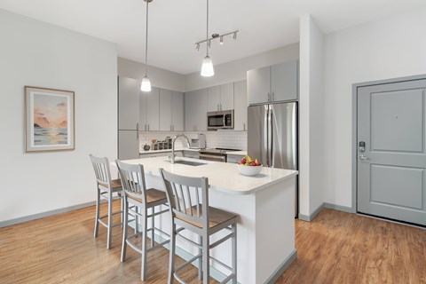 A kitchen with a white countertop and stainless steel appliances.