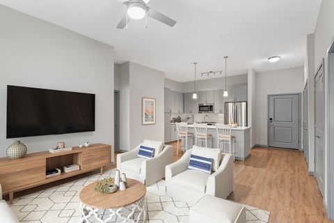 A living room with a television, white chairs, and a wooden coffee table.