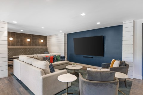 A modern living room with a grey sofa and a large television.