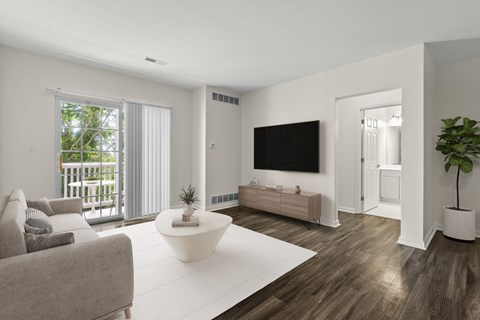 A modern living room with a grey couch, a white coffee table, and a flat screen TV.