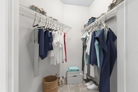 A white closet with clothes hanging on a rack.