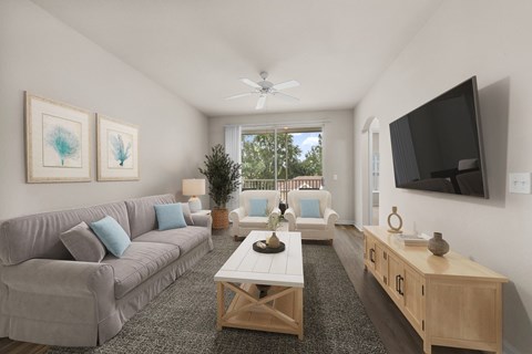 A living room with a grey couch, a wooden coffee table, and a flat screen TV mounted on the wall.