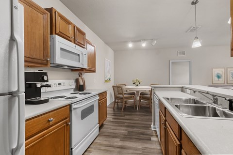 A kitchen with wooden cabinets and white appliances.