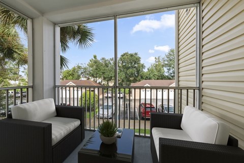 A patio with a table, two chairs and a couch.