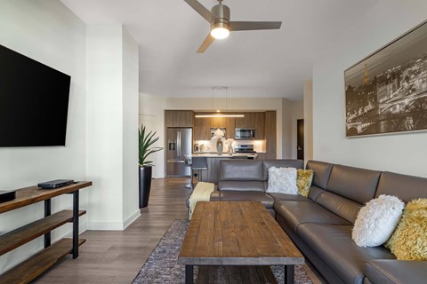 A modern living room with a brown leather couch and a wooden coffee table.