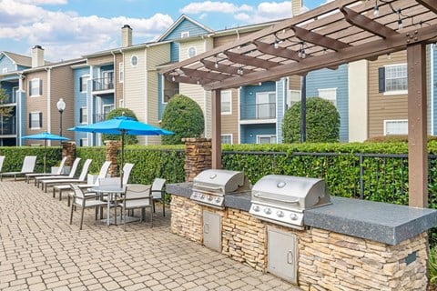 Patio with a grill and chairs under a pergola at Thornberry Apartments, Charlotte, NC, North Carolina