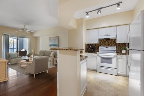 A modern kitchen with an open concept layout that opens up into the living room