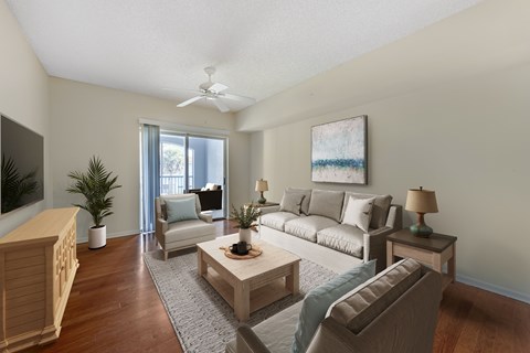A living room with a couch, a chair, a coffee table, and a painting on the wall.