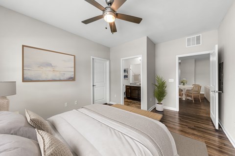 A bedroom with a large bed and a ceiling fan.