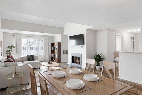 A modern dining room with a fireplace and a TV mounted on the wall.