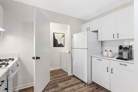 A kitchen with white appliances and cabinets.