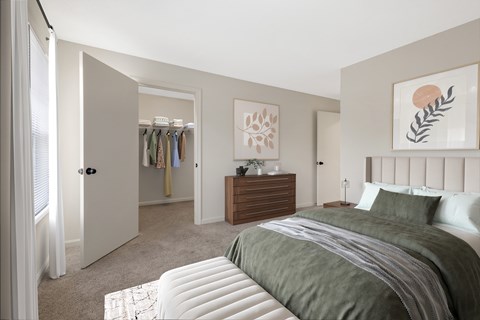 A bedroom with a large bed and a wooden dresser.